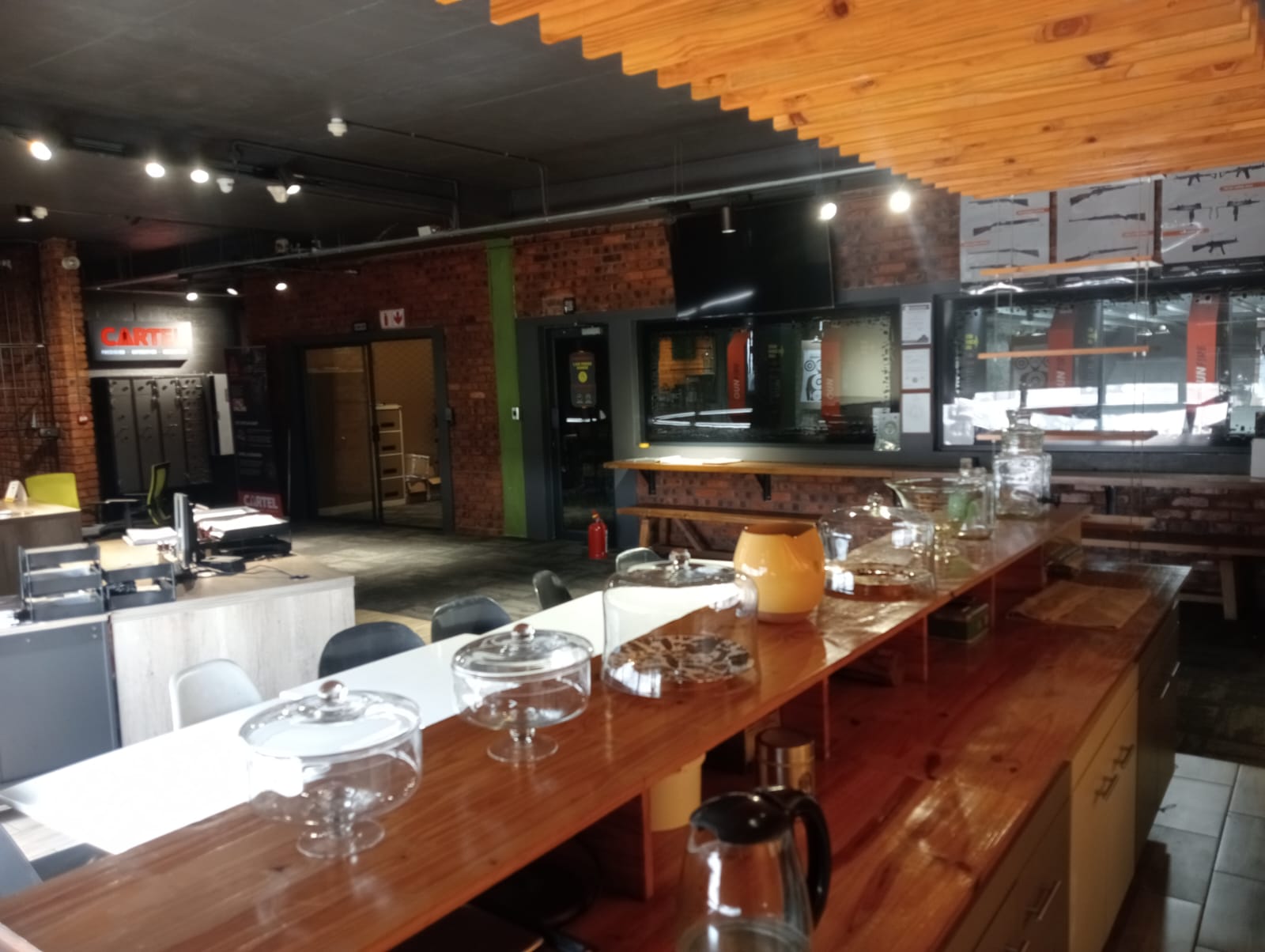 Coffee bar counter in the CARTEL lounge with glass display jars and a drinks fridge