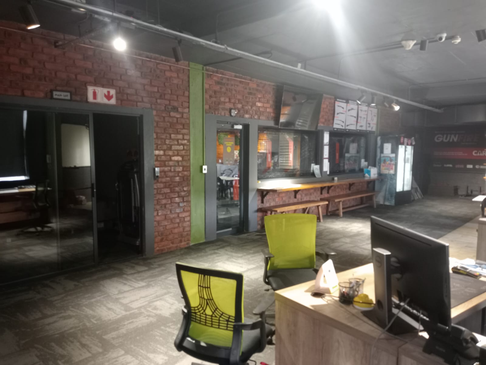 Reception desk with screens, green office chairs and the range viewing counter