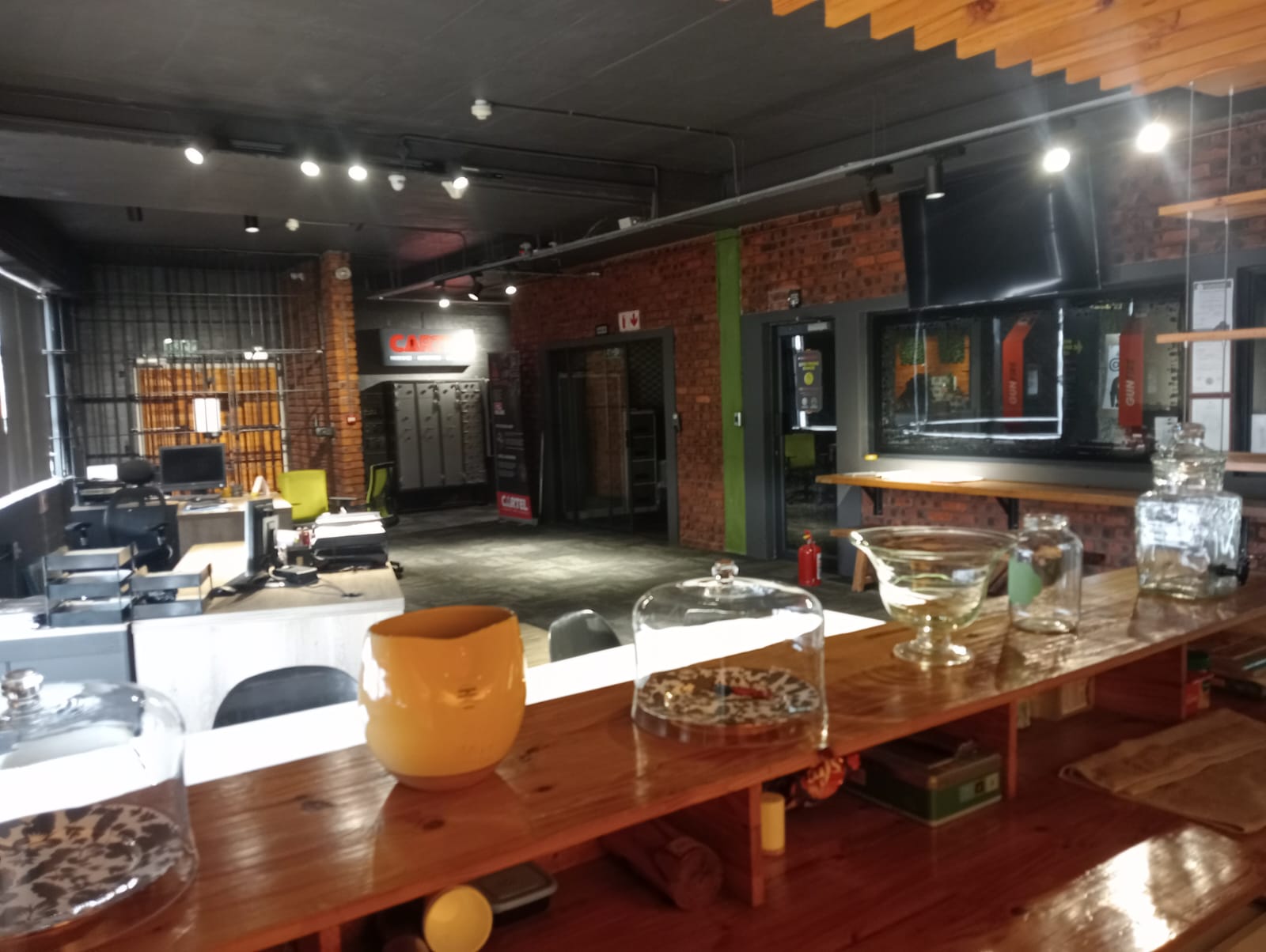 Timber coffee bar counter with glass display jars under a wooden ceiling