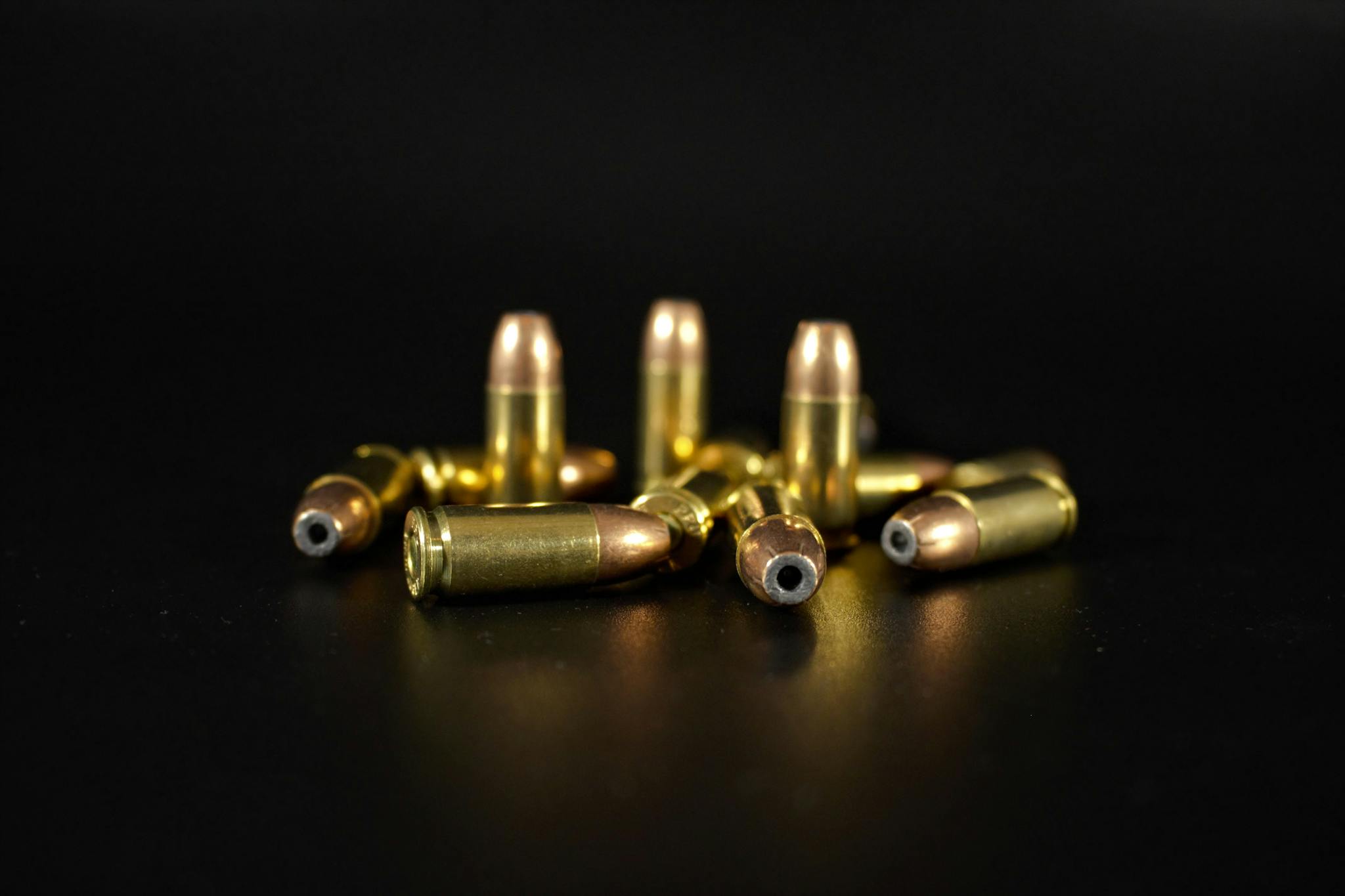 A detailed close-up of several brass and copper bullets on a dark background.